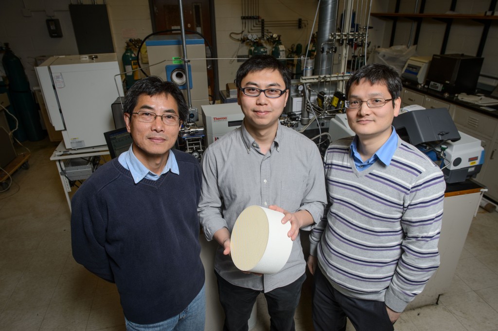 Industry mentor Wen Fu, left, Yanbing Guo, and Pu-Xian Gao with a sample of the catalyst they have developed. (Peter Morenus/UConn Photo)