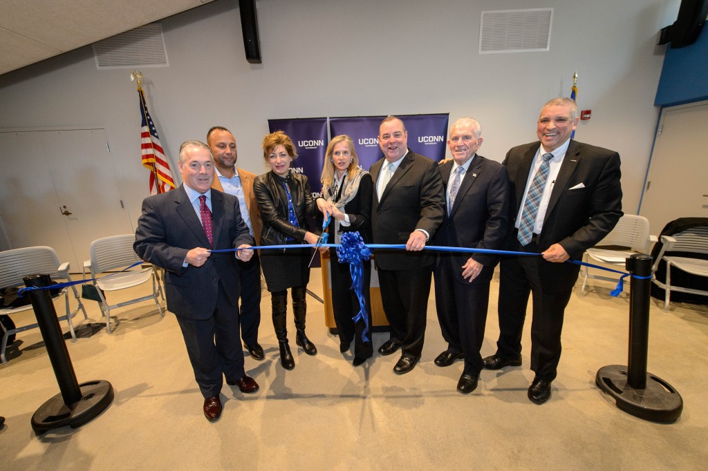 State Rep. Jeffrey Berger, left, State Rep. Victor Cuevas, President Susan Herbst, State Sen. Joan Hartley, Mayor Neil O'Leary, Larry McHugh, chair of the Board of Trustees, and William Pizzuto, campus director, cut the ribbon during the dedication ceremony for the Rectory Building at the Waterbury Campus on Jan. 5, 2016. (Peter Morenus/UConn Photo)