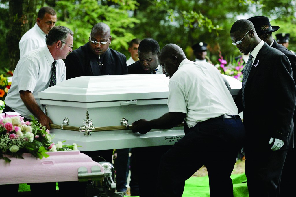 The casket of 6-year-old Samenia Robinson is laid to rest at alongside her mother Detra Rainey, 39, and three brothers William Rainey, 16, Hakiem Rainey, 13, Malachai Robinson, 8, at Hillsboro Brown Cemetery in West Ashley in 2006. Detra Rainey's husband was accused of fatally shooting her and his stepchildren inside their North Charleston mobile home. Alan Hawes/The Post and Courier (UConn Magazine photo)