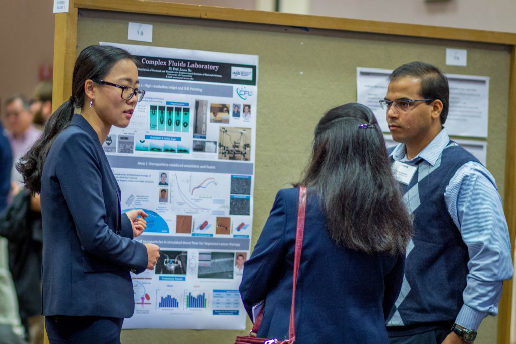 Two graduate students in engineering, Yang Guo, left, and Huseini Patanwala, speak with an industry partner during the School of Engineering's Open House in November 2015. (Chris LaRosa/UConn Photo)