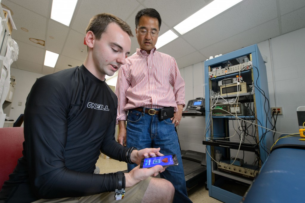 Cameron Flower, a biomedical engineering student demonstrates an ECG sensor and smartphone health sensor with Ki Chon, chair of biomedical engineering on April 22, 2016. (Peter Morenus/UConn Photo)