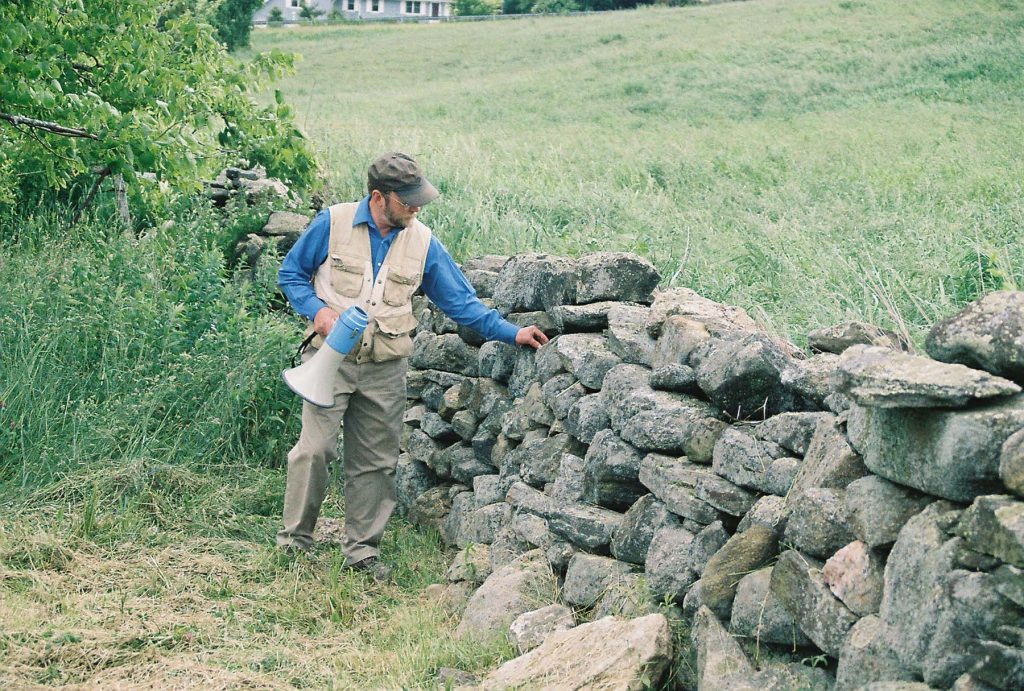 Geologist Robert Thorson examines a stone wall.