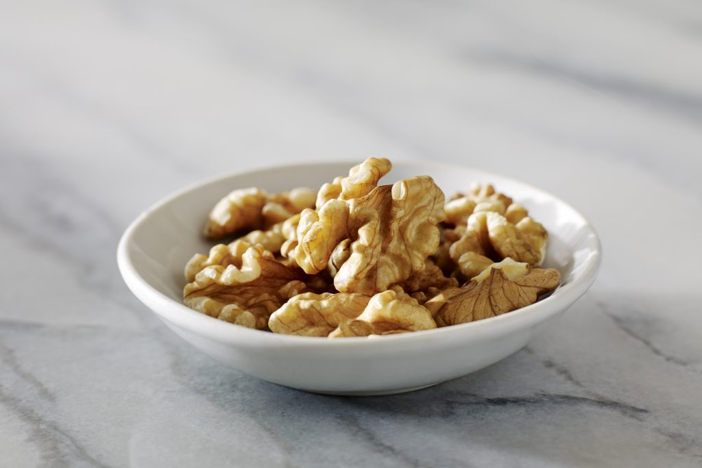 Walnuts in a dish on a marble background. (Photo: California Walnut Commission)
