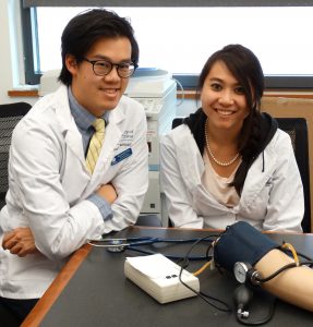 Pharmacy students with blood pressure simulation arm.