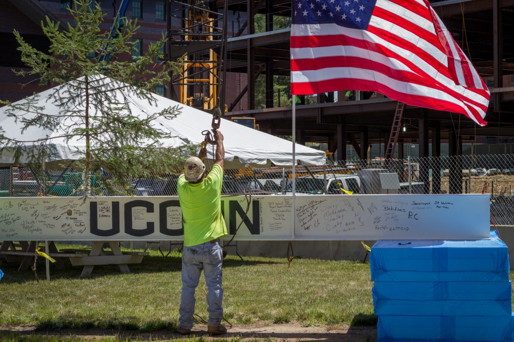A construction worker prepares the final beam for hoisting.