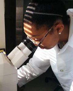 Tiahna Spencer investigates the status of the cells after culturing them during her summer research internship at the National Institutes of Health. (Photo by Ronnie Gladney)