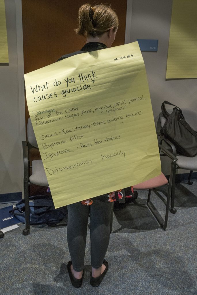 A participant in the 2016 Intellectual Humility in Secondary Education Summer Institute displays a worksheet with answers to the question, What do you think causes genocide? at the Thomas J. Dodd Research Center on Aug. 1, 2016. (Sean Flynn/UConn Photo)
