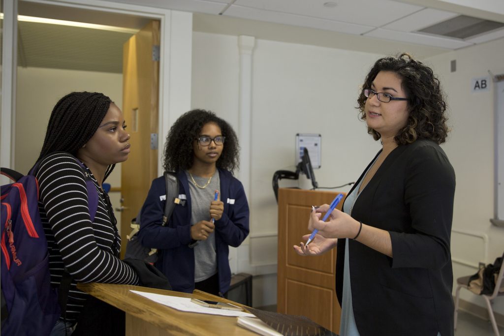 Postdoctoral fellow Shannon Gleason, who teaches the course 'Gender, Culture and Science,' speaks with Arabia Henley '18 (CLAS), left, an English major, and Moesha Outar '20 (CLAS), a math major, after midterm presentations. (Bri Diaz/UConn Photo)