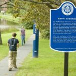 Students walk past a historic marker placed near Mirror Lake.