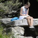 Emily Nirshberg, a 7th semester English major, studies alongside mirror lake.