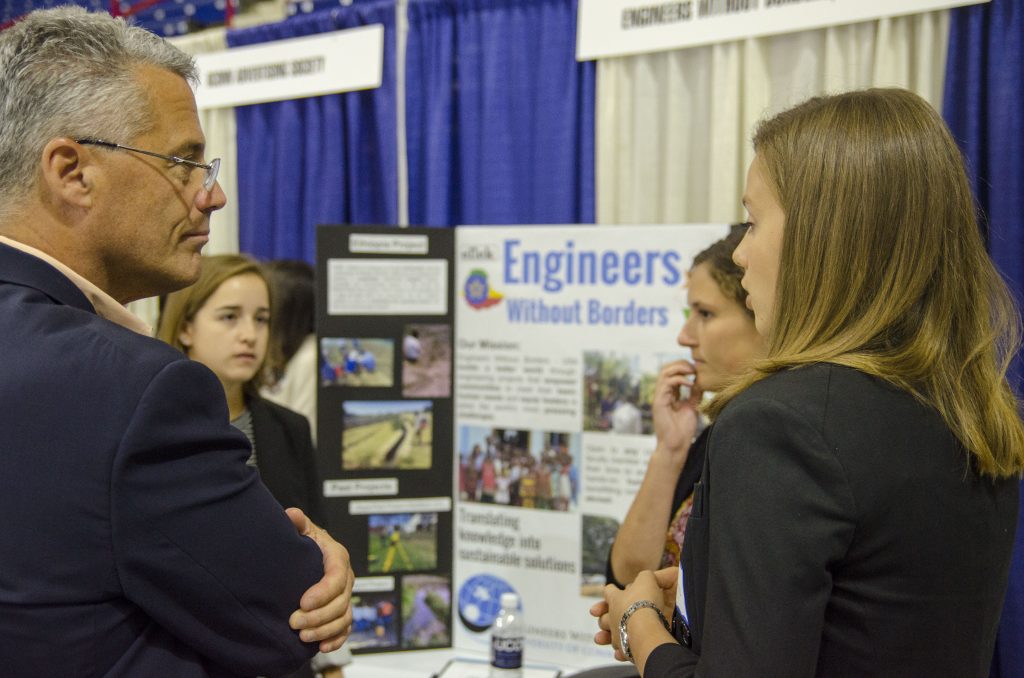 From left, Jennifer Skoog '19 (ENG), Megan Leether '17 (ENG), and Georgina Talbot '17 (ENG), speak with business leaders about Engineering without Borders at Gampel Pavilion. Oct. 5, 2016. (Garrett Spahn '18 (CLAS)/UConn Photo)