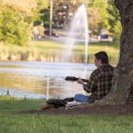 Playing the guitar at Mirror Lake on Sept. 26, 2016. (Sean Flynn/UConn Photo)