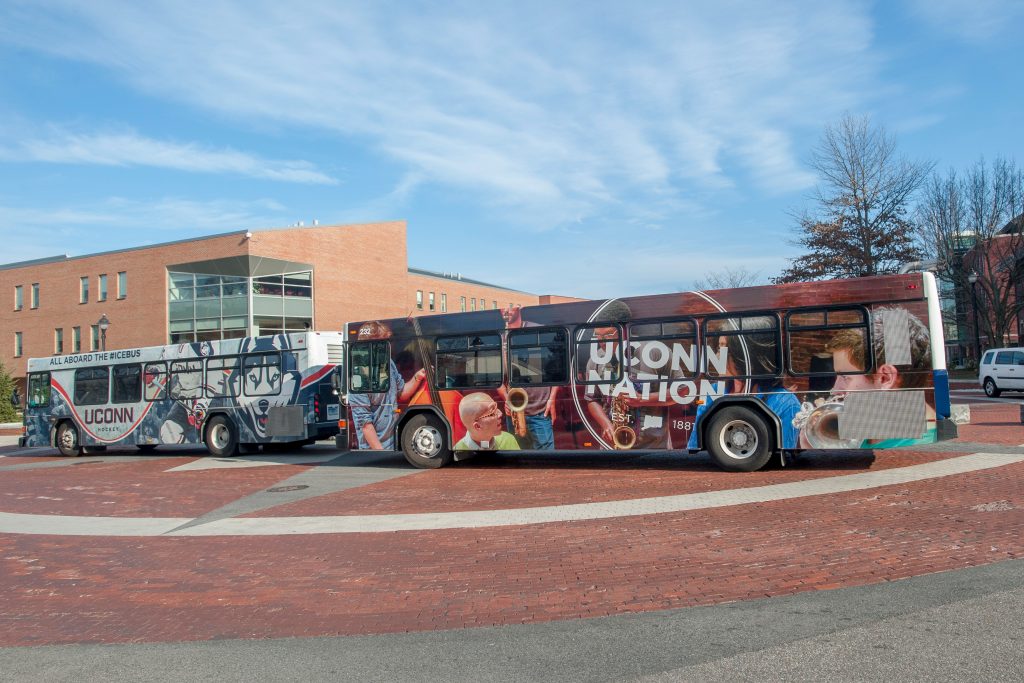 A UConn Nation transportation bus, right, and the Icebus, on Hillside Road. (Sean Flynn/UConn Photo)