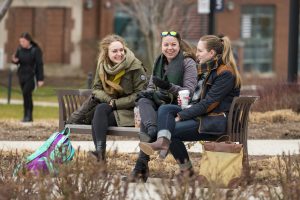 A group of friends talking and laughing near the sundial on Jan. 17, 2017. (Sean Flynn/UConn Photo)