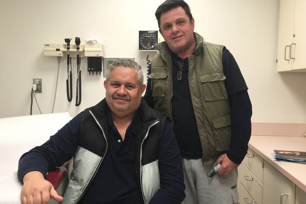 Eliseo Bonilla, seated, and his husband, Lesme Valentin, at UConn Health, where Bonilla was successfully treated for a deep vein thrombosis. (Lauren Woods/UConn Health Photo)