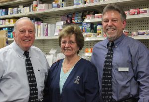 Edmund J. Funaro, Sr., Janet Funaro, and Edmund J. Funaro, Jr., at Visels Pharmacy - their home away from home in New Haven. (Sheila Foran/UConn Photo)
