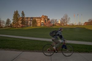 A student riding his bicycle to class along Route 195. (Sean Flynn/UConn Photo)