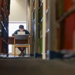 A student studies amid the stacks in Homer Babbidge Library in 2017. In the future, the stacks will occupy less space, and will be moved away from the windows to let in more light. (Sean Flynn/UConn Photo)