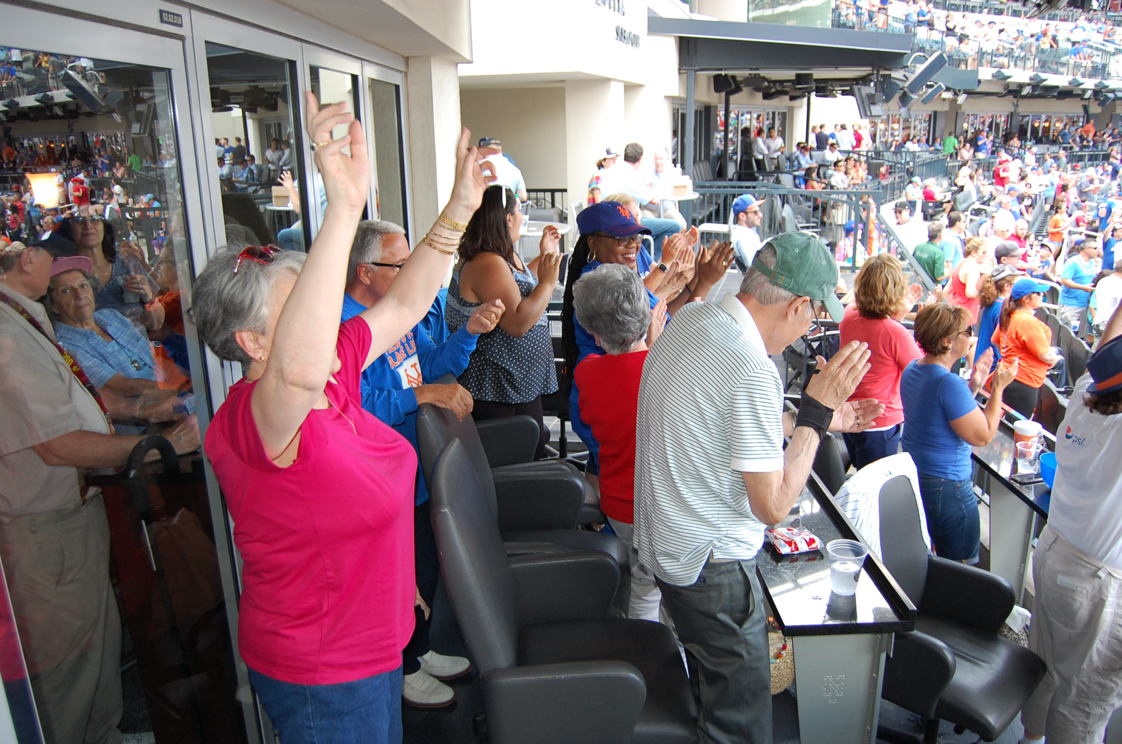 Participants and staff from the River House Adult Care Center in Cos Cobb, Connecticut, cheering on the New York Mets at Citi Field in New York City, as part of the Baseball Reminiscence Program. (Kenneth Best/UConn Photo)