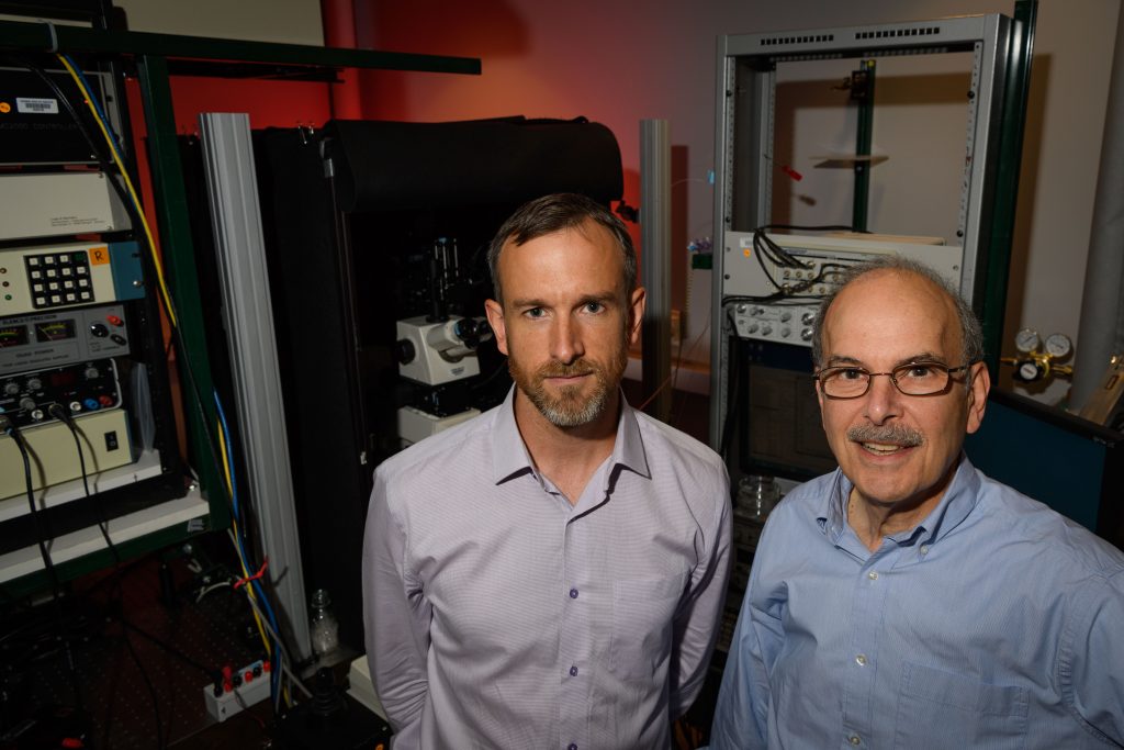 Corey Acker, left, and Les Loew in the lab at the Cell and Genome Sciences Building at UConn Health in Farmington on Aug. 4, 2017. (Peter Morenus/UConn Photo)