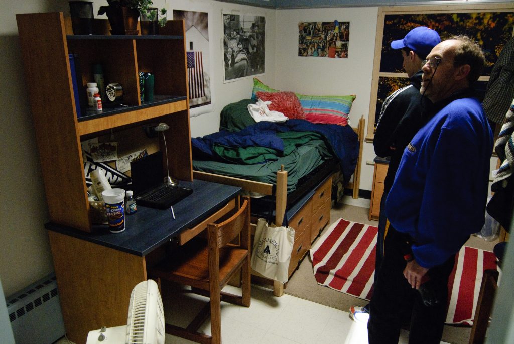 Prospective students and parents look at the Model Room - a model of what a double in a dorm looks like.