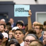 A student holds a #OneUConn sign during the rally. Speaker after speaker warned of the risks to financial aid, academic life, the University’s ability to serve as an economic growth engine for Connecticut, and the national reputation that UConn has won for itself and its state. (Peter Morenus/UConn Photo)