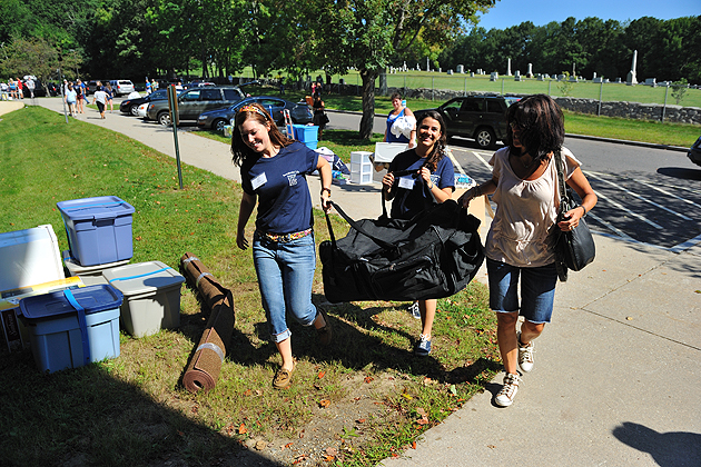 Husky Haulers Lauren Cunningham '13 (CLAS), left, and Monica Vaughn-Flam '13 (CLAS) help a student carry her belongings to her room at the North Campus Residence Complex on Aug. 26, 2011.