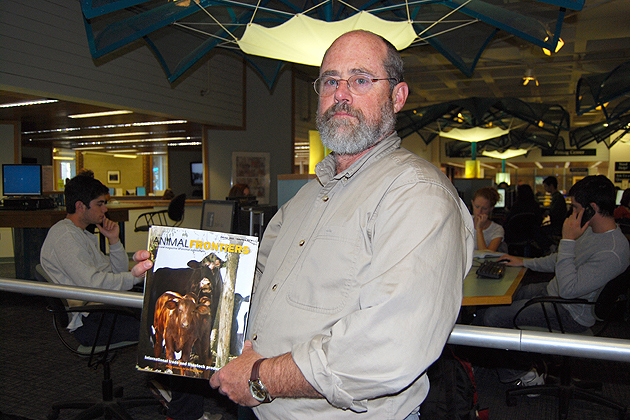 Animal science professor Steve Zinn with an issue of the open access journal Animal Frontiers in Babbidge Library. Zinn is editor-in-chief of the journal. Open access is the focus of a week-long celebration at the University Libraries Oct. 24-30. (Suzanne Zack/UConn Photo)