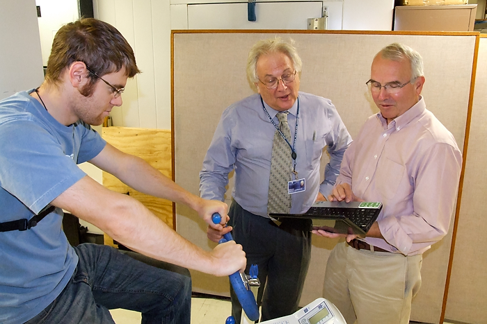 From left: Graduate student Drew Seils, Dr. Martin Cherniack, and Tim Morse demonstrate an exercise bike test in the Ergonomics Technology Center. (Chris DeFrancesco/UConn Health Center Photo)