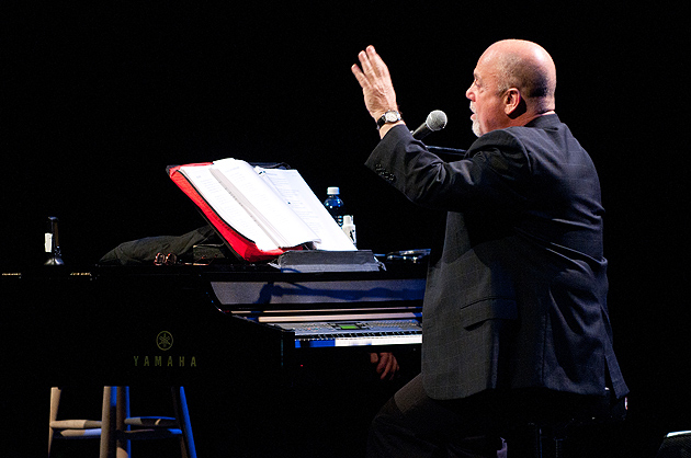 Billy Joel reviews the lyrics to his song 'Summer, Highland Falls,' while answering a question from the audience during a lecture and concert at the Jorgensen Center for the Performing Arts on Nov. 29, 2011. (Peter Morenus/UConn Photo)