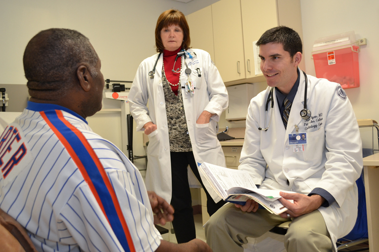 Dr. Jason Ryan and cardiology nurse practitioner Marybeth Barry talk with a patient in the Calhoun Cardiology Center.