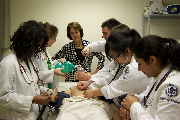 Dr. Lynn Kosowicz, medical director of the Clinical Skills Assessment Program, oversees medical students as they work on a "SimMan" high-tech mannequin in the simulation center. (UConn Health Center Photo)