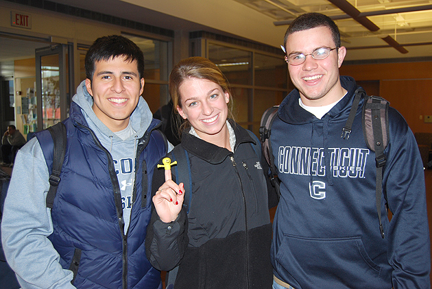 Christian Tuesta, sophomore, Lauren McKulla, fresman, and Paul Levesque, all nursing majors, were tickled by the stress relief items distributed by the Health Education Office and University Libraries in Homer Babbidge Library on Dec. 12. (Suzanne Zack/UConn Photo)