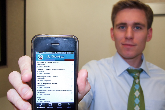 Dan Henderson, fourth-year medical student, shows his iPhone app "Safecheck." (Chris DeFrancesco/UConn Health Center Photo)