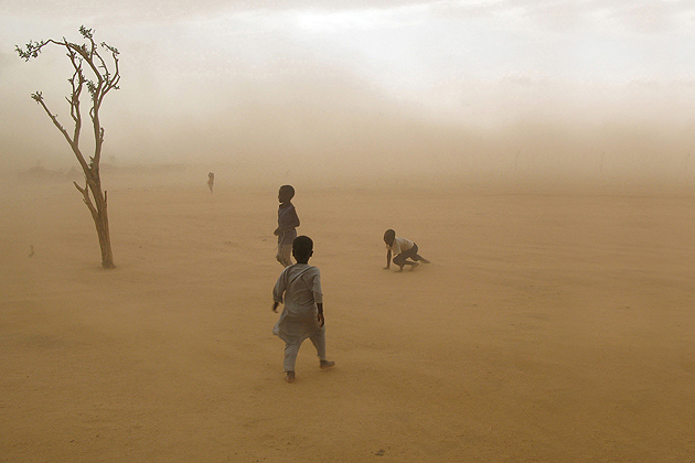 Boys fleeing violence along the border of Darfur and Chad as a sandstorm approaches, 2007