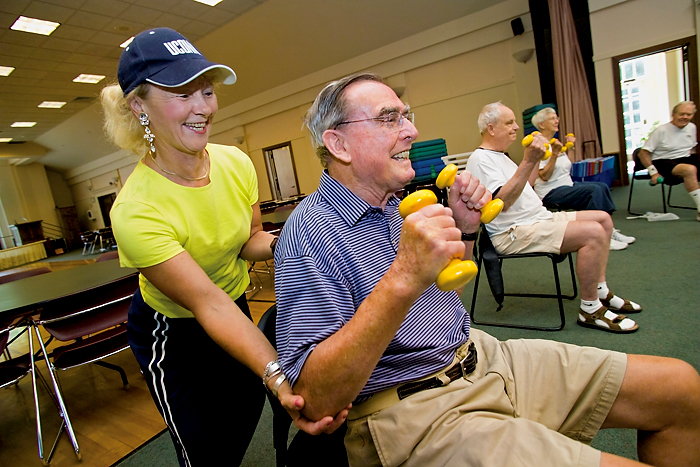 Mary Carroll Root helps participants during a Powerful Aging Exercise class at the Avon Senior Center. (Al Ferreira for UConn Health Center)