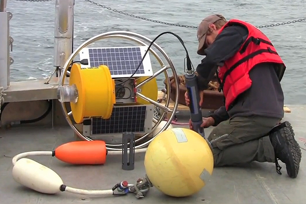 Christian Fox prepares a UConn buoy for deployment out at sea.