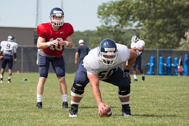 Tyler Bullock '14 snaps the ball to quarterback Chandler Whitmer '14 (CLAS) during the UConn football team's open practice held on the Storrs campus on Aug. 7, 2012. (Peter Morenus/UConn Photo)