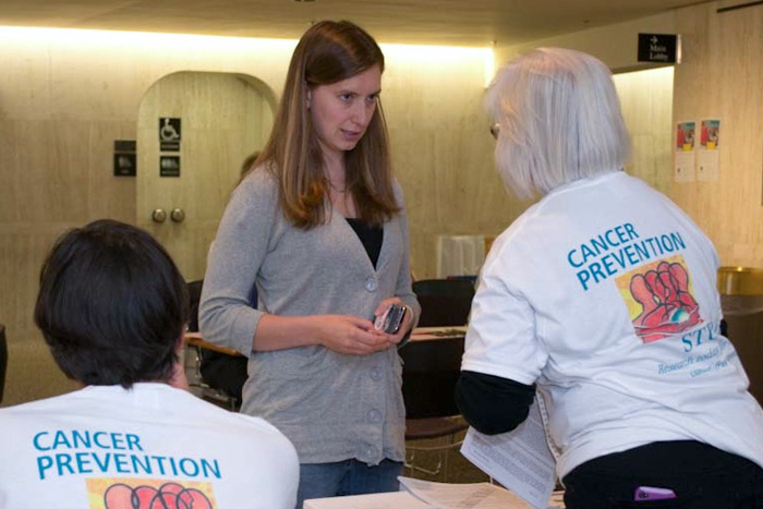 American Cancer Society staffers explain next steps to CPS-3 participant Jen Cyr, who had just submitted her enrollment questionnaire. (Tina Encarnacion/UConn Health Center Photo)