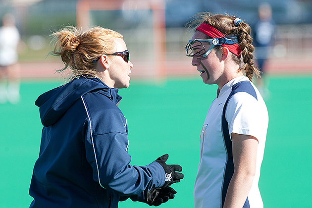 Lacrosse head coach Katie Woods (left) gives instructions to a player. (Steve Slade '89 (SFA) for UConn)