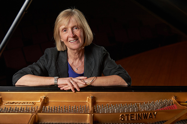 Brid Grant, dean of fine arts, sits at a Steinway grand piano on the stage of von der Mehden Recital Hall on April 2, 2013. (Peter Morenus/UConn Photo)
