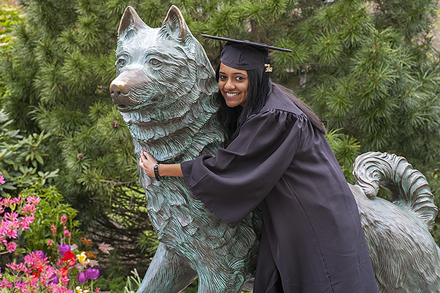 2012 graduates of the University of Connecticut pose for pictures near Jonathan the husky dog statue on May 6, 2012. (Sean Flynn/UConn Photo)
