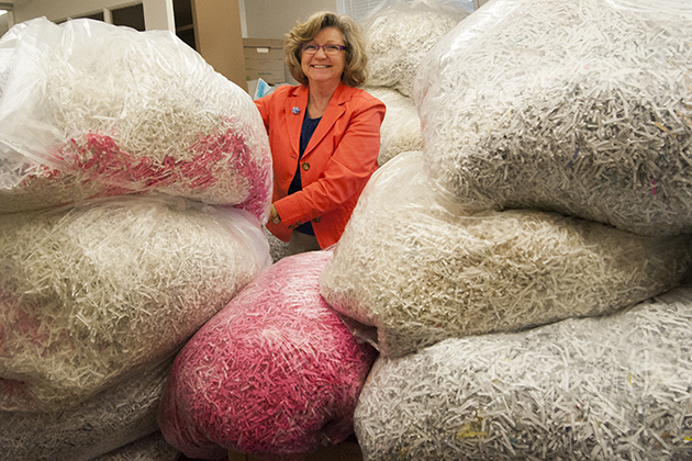 Cheryl H. Williams, Program Specialist surrounded by bags of shredded professor evaluations on April 11, 2013. (Sean Flynn/UConn Photo)