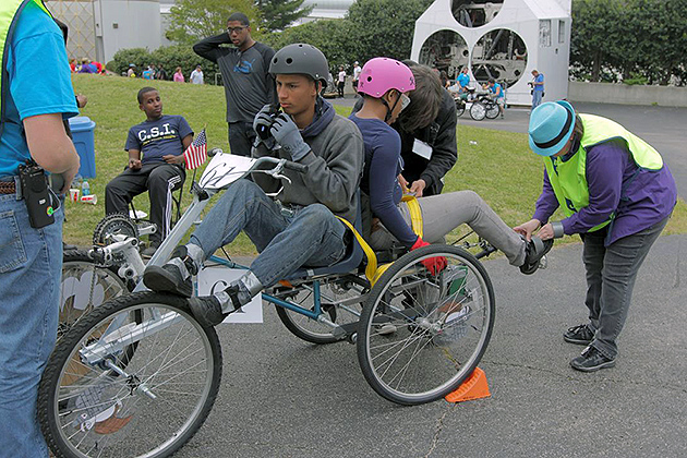 Moonbuggy drivers Ricardo Santiago (left/center) and Ebony McWaynson undergo a safety inspection before beginning their race. (Cathy Torrisi/UConn Photo)