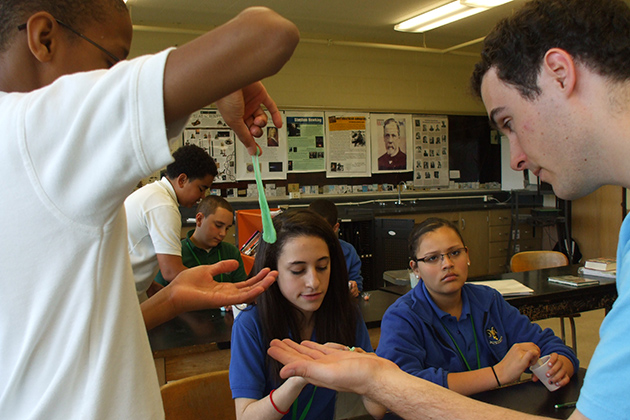 UCoUConn science Wizard and future physics teacher Peter Dufner '12 (CLAS), '13 MA, right, helps an Illing Middle School 8th grader test his poly putty. (Cathy Torrisi/UConn Photo)