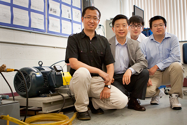 Pratt & Whitney Chair professor Robert Gao, second from left, with (left to right) Zhaoyan Fan, assistant research professor of mechanical engineering, and Ph.D. students Peng Wang and Jinjiang Wang, with a drivetrain prognostic simulator. (Chris LaRosa/UConn Photo)