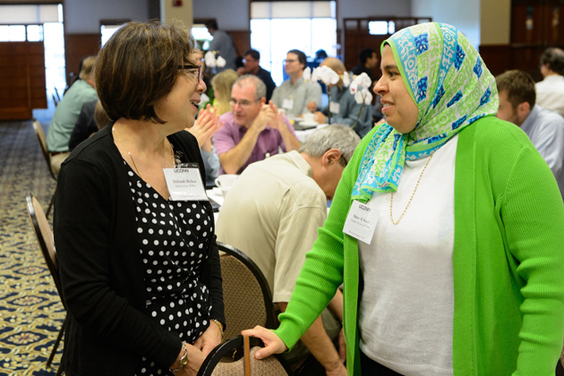 Deborah Shelton, left, and Sahar Al Seesi, speak at at the new faculty orientation session held at Rome Ballroom on Aug. 23, 2013. (Peter Morenus/UConn Photo)