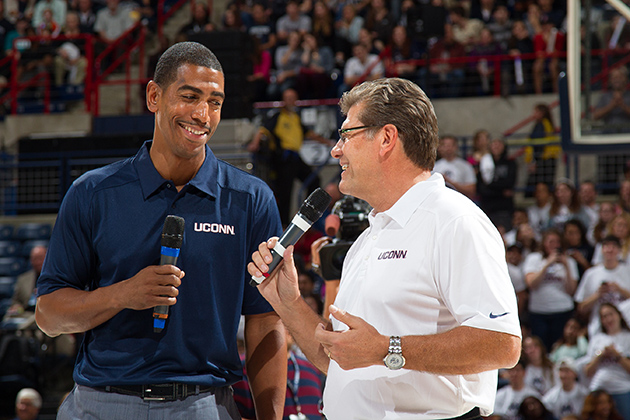 Men's basketball head coach Kevin Ollie, left, and women's basketball head coach Geno Auriemma engage in a friendly exchange at First Night in Gampel Pavilion on Oct. 18, 2013. (Steve Slade '89 (SFA) for UConn)