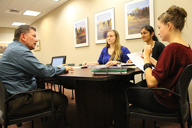 From left to right: Bernard Grela, associate professor and head of the Department of Speech, Language, and Hearing Sciences, and master’s students Carrie Adams, Minal Kadam, and Sarah Smialek, discuss the progress of the Read to Succeed students. (Bri Diaz/UConn Photo)