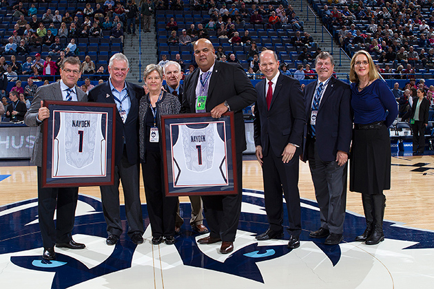 Alumni Denis and Britta Nayden, second and third from left, were honored for their $3 million commitment to the UConn basketball program during the women's game at the XL Center on Dec. 5. From left: Coach Geno Auriemma, Denis Nayden, Britta Nayden, UConn Board of Trustees Chairman Lawrence McHugh, Director of Athletics Warde Manuel, President of the UConn Foundation Joshua Newton, School of Business Dean John Elliott, and SNY analyst and former UConn Husky Meghan Pattyson-Culmo. (UConn Foundation Photo)